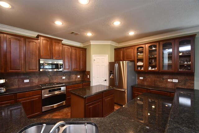 kitchen with decorative backsplash, appliances with stainless steel finishes, a textured ceiling, crown molding, and sink