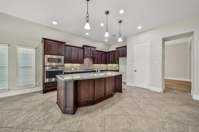 kitchen with pendant lighting, appliances with stainless steel finishes, tasteful backsplash, dark brown cabinets, and light stone counters