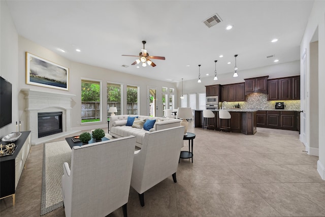 tiled living room featuring ceiling fan and a healthy amount of sunlight