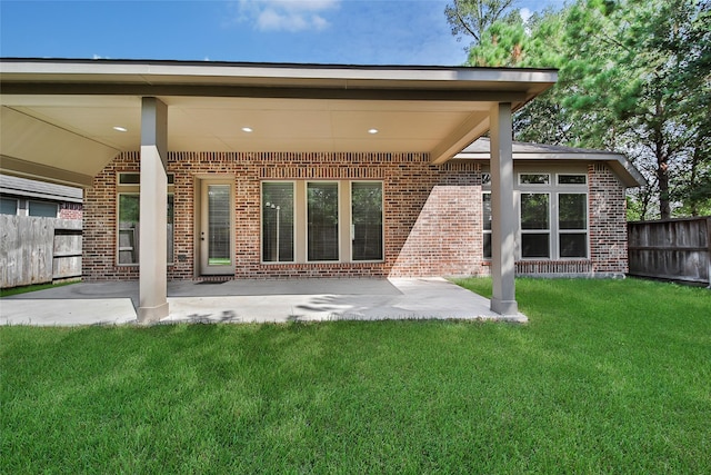 rear view of property featuring a yard and a patio