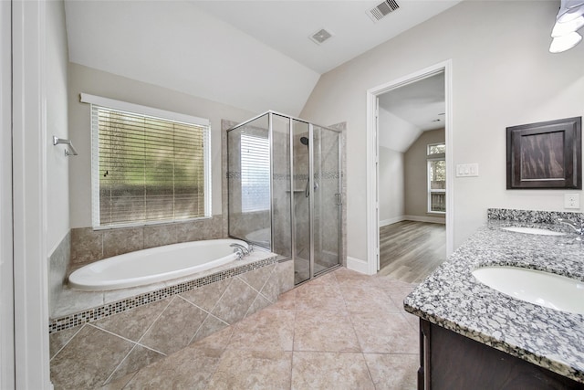 bathroom with tile patterned flooring, vanity, independent shower and bath, and lofted ceiling