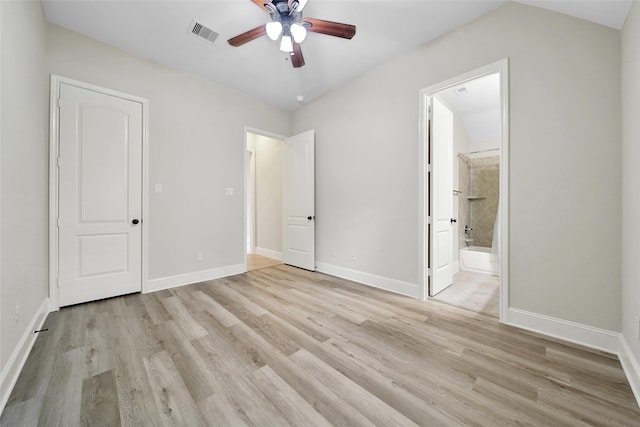 unfurnished bedroom with ceiling fan, ensuite bathroom, and light wood-type flooring