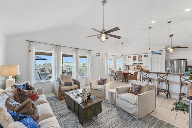 tiled living room featuring vaulted ceiling, a wealth of natural light, and ceiling fan