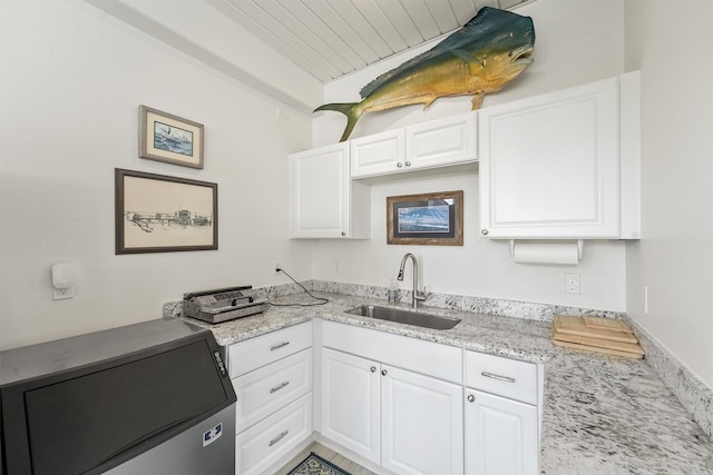 kitchen with light stone countertops, sink, wooden ceiling, fridge, and white cabinets