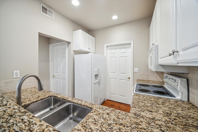 kitchen with white appliances, sink, tasteful backsplash, light stone counters, and white cabinetry