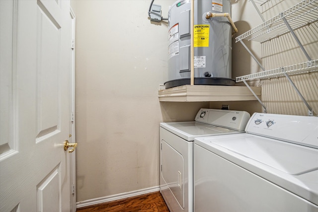 clothes washing area with dark hardwood / wood-style flooring, electric water heater, and washer and clothes dryer