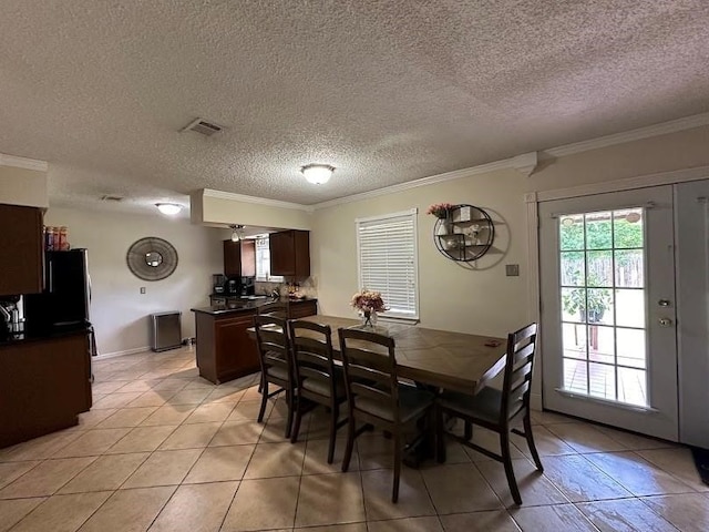 dining room with crown molding, light tile patterned floors, and a textured ceiling