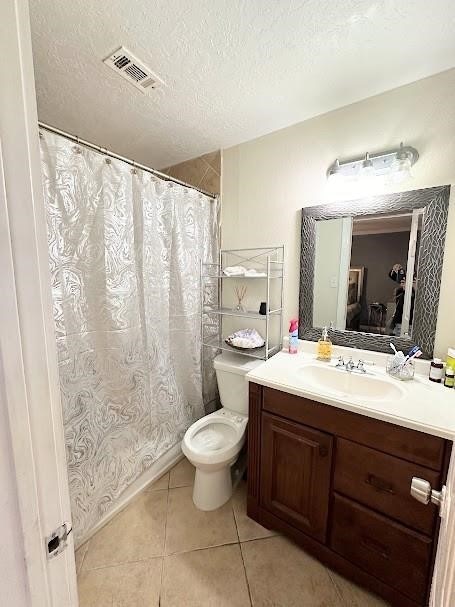 bathroom featuring vanity, tile patterned floors, a textured ceiling, and toilet