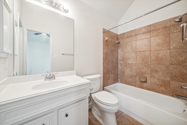 full bathroom featuring tiled shower / bath combo, tile patterned floors, vaulted ceiling, toilet, and vanity