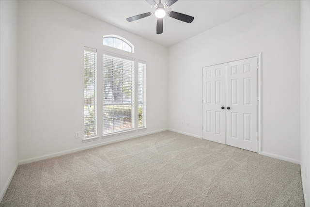 unfurnished room featuring light carpet, plenty of natural light, and ceiling fan