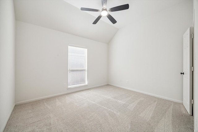 empty room featuring light carpet, ceiling fan, and vaulted ceiling