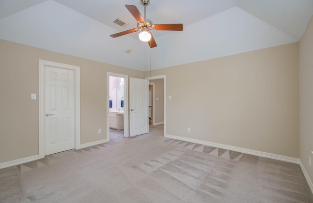 unfurnished bedroom with vaulted ceiling, ceiling fan, ensuite bathroom, and light colored carpet