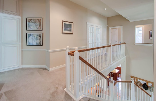 corridor featuring light carpet and french doors