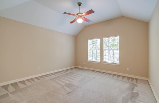 spare room featuring ceiling fan, lofted ceiling, and light colored carpet