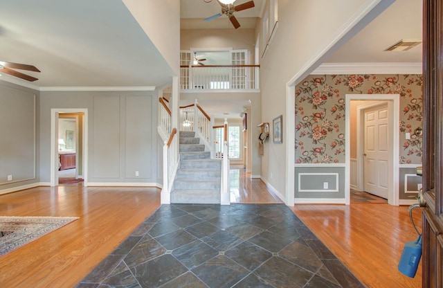 foyer featuring ceiling fan and ornamental molding