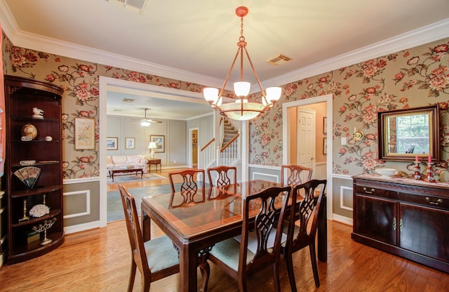 dining room featuring crown molding, a chandelier, and light hardwood / wood-style flooring