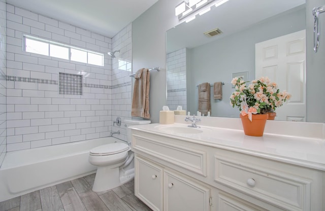 full bathroom featuring toilet, vanity, and tiled shower / bath