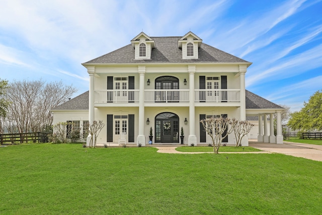 view of front of property with a front yard, french doors, a balcony, and a garage