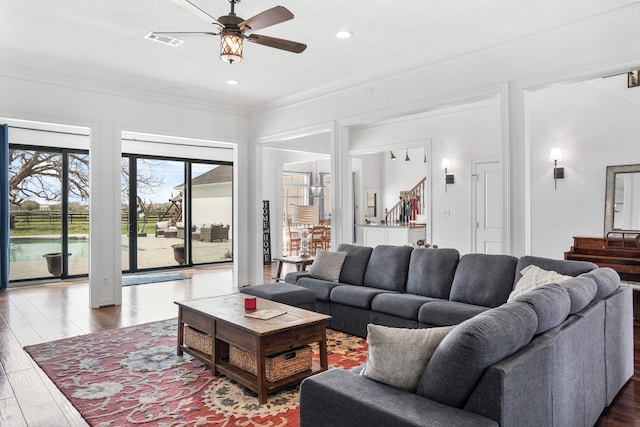 living room with dark hardwood / wood-style floors, ceiling fan, and crown molding