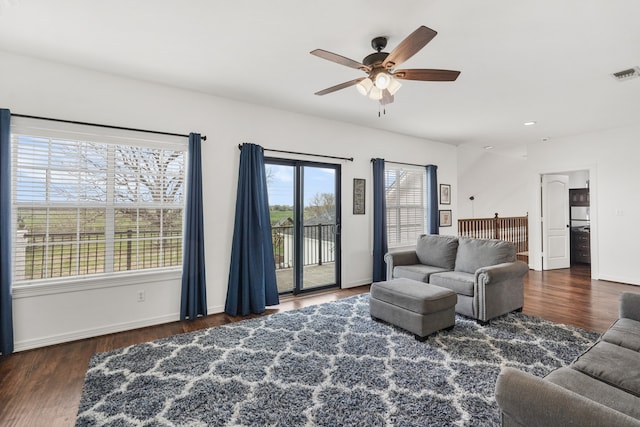 living room featuring ceiling fan and dark hardwood / wood-style flooring