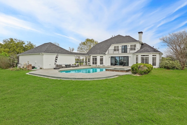 rear view of house with a yard, a balcony, a patio, and a pool with hot tub