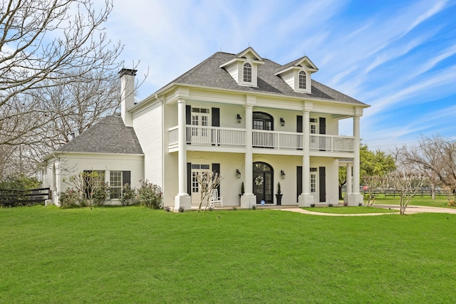 view of front of home featuring a front yard, a porch, and a balcony