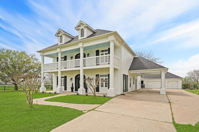 greek revival house with a front yard, a porch, and a balcony