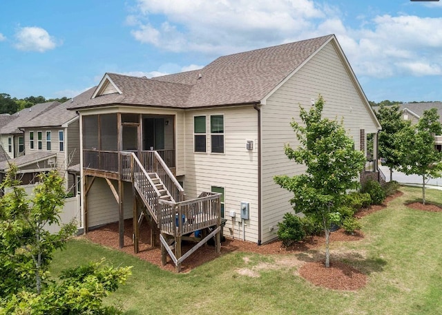 rear view of house featuring a sunroom, a yard, and a deck