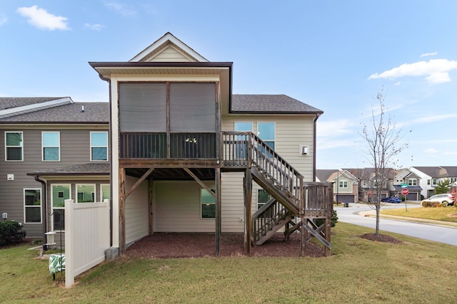 rear view of property with a lawn and a sunroom