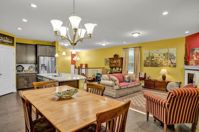 dining area with dark hardwood / wood-style floors, a notable chandelier, and sink