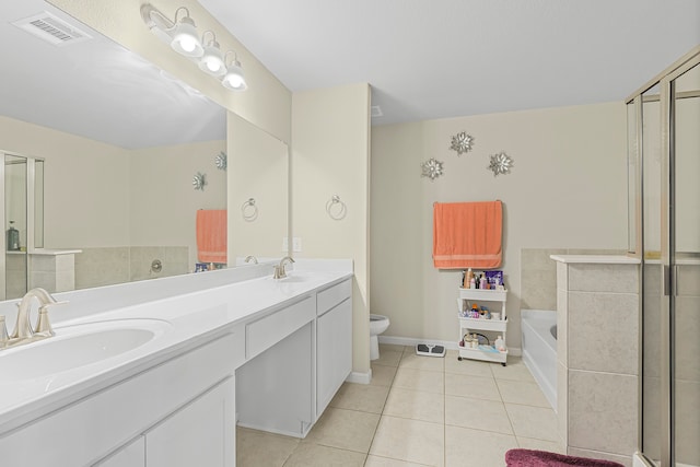 bathroom with tile patterned flooring, vanity, toilet, and a tub