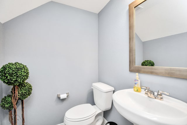 12810 Ilderton Dr, Humble, TX 77346 - half bathroom featuring a sink, toilet, lofted ceiling, and baseboards