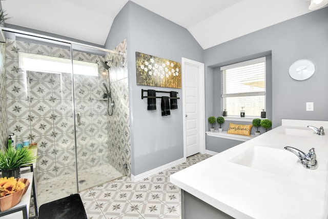 bathroom featuring vanity, tiled shower, and vaulted ceiling