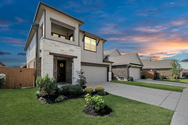 view of front of home with a garage and a lawn