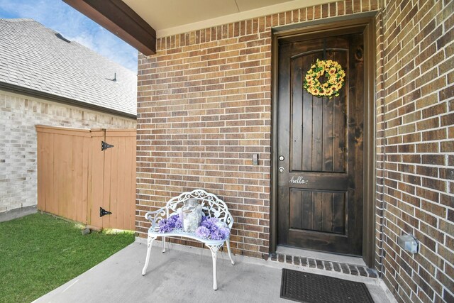 12810 Ilderton Dr, Humble, TX 77346 - view of exterior entry featuring brick siding and a porch