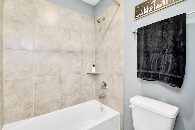 bathroom with toilet and tiled shower / bath