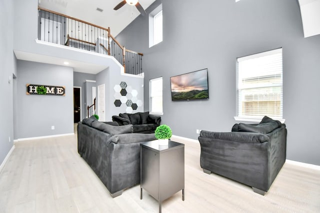 12810 Ilderton Dr, Humble, TX 77346 - living area with a high ceiling, ceiling fan, baseboards, light wood finished floors, and stairway