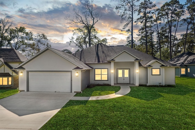 view of front of house with french doors, a yard, and a garage