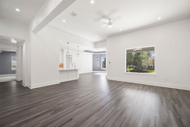 unfurnished living room with ceiling fan, sink, and dark hardwood / wood-style floors