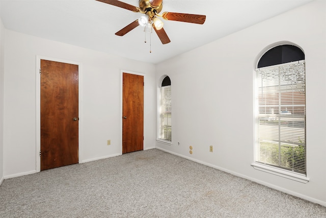 spare room with ceiling fan and light colored carpet