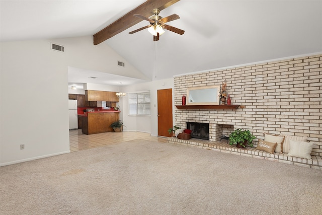 unfurnished living room with a fireplace, beamed ceiling, high vaulted ceiling, light colored carpet, and ceiling fan with notable chandelier