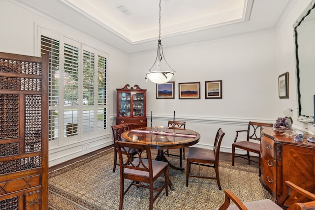 dining area featuring a raised ceiling and crown molding