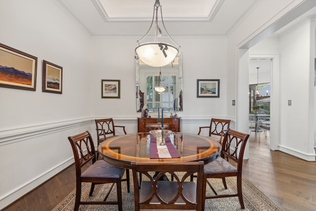 dining area featuring a raised ceiling, crown molding, and dark hardwood / wood-style floors