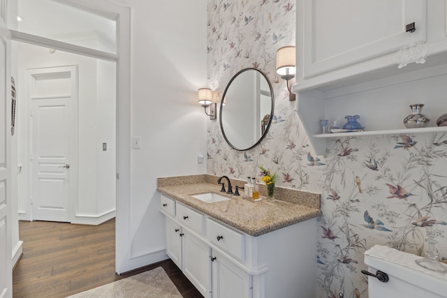 bathroom with hardwood / wood-style flooring, vanity, and toilet