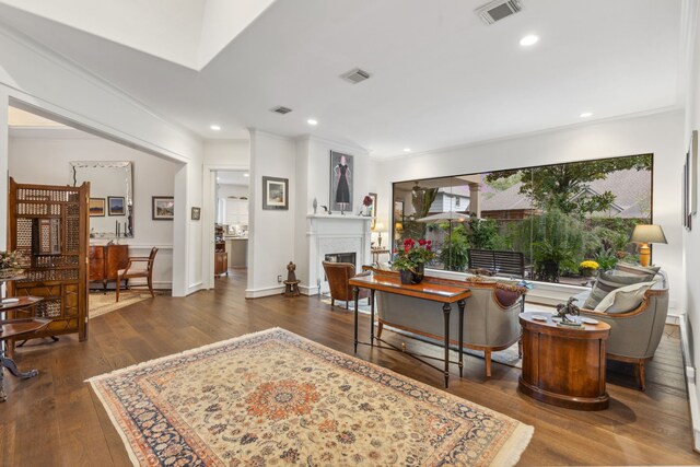 living room with ornamental molding and dark wood-type flooring