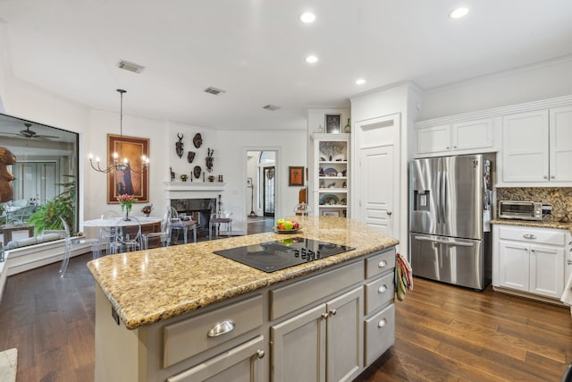 kitchen with white cabinets, stainless steel refrigerator with ice dispenser, black electric cooktop, decorative light fixtures, and a kitchen island