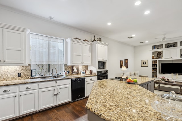 kitchen with black appliances, sink, ceiling fan, light stone countertops, and white cabinetry