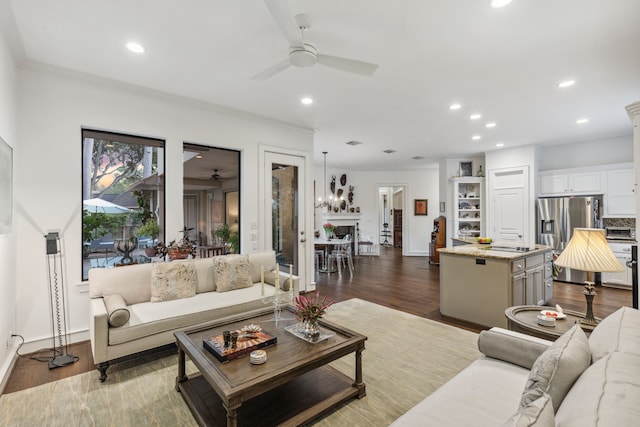 living room with dark hardwood / wood-style floors, ceiling fan, and ornamental molding