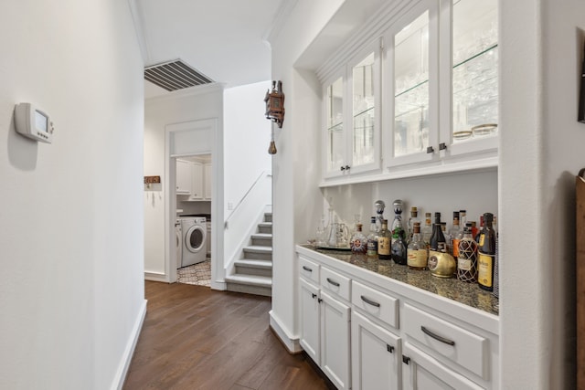 bar with crown molding, white cabinets, and dark wood-type flooring