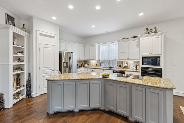 kitchen with a center island, light stone counters, dark hardwood / wood-style flooring, white cabinets, and black appliances